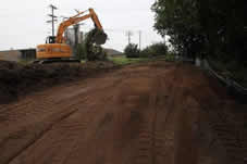 A backhoe clears brush, Thursday, July 28, 2011, as work continues on the River Edge Parkway trail on the Marathon Electric Property in Wausau.